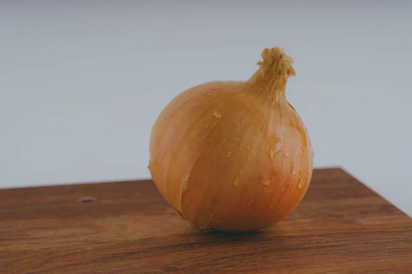 木の板 白い背景の上に新鮮な玉ねぎ 健康ダイエットのための野菜 玉ねぎは ビタミン 便利に富んでいます 木製の背景にタマネギの皮 ヘルシーなサラダのための成分 — ストック写真