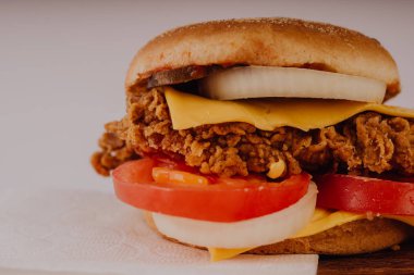 Ev yapımı hamburger veya kahverengi kağıt üzerinde sandviç. Lezzetli sandviç hamburger eti veya domuz jambon peynir ve taze sebze ile. Hamburger veya sandviç popüler fast food brunch veya öğle yemeği için olur. Peynir