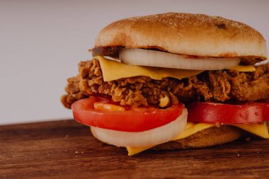 Ev yapımı hamburger veya kahverengi kağıt üzerinde sandviç. Lezzetli sandviç hamburger eti veya domuz jambon peynir ve taze sebze ile. Hamburger veya sandviç popüler fast food brunch veya öğle yemeği için olur. Peynir