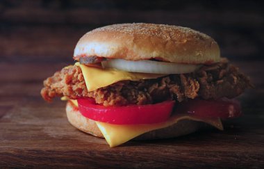 Ev yapımı hamburger veya kahverengi kağıt üzerinde sandviç. Lezzetli sandviç hamburger eti veya domuz jambon peynir ve taze sebze ile. Hamburger veya sandviç popüler fast food brunch veya öğle yemeği için olur. Peynir