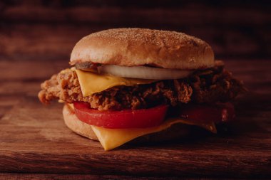 Ev yapımı hamburger veya kahverengi kağıt üzerinde sandviç. Lezzetli sandviç hamburger eti veya domuz jambon peynir ve taze sebze ile. Hamburger veya sandviç popüler fast food brunch veya öğle yemeği için olur. Peynir