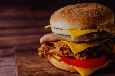 Ev yapımı hamburger veya kahverengi kağıt üzerinde sandviç. Lezzetli sandviç hamburger eti veya domuz jambon peynir ve taze sebze ile. Hamburger veya sandviç popüler fast food brunch veya öğle yemeği için olur. Peynir