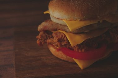 Ev yapımı hamburger veya kahverengi kağıt üzerinde sandviç. Lezzetli sandviç hamburger eti veya domuz jambon peynir ve taze sebze ile. Hamburger veya sandviç popüler fast food brunch veya öğle yemeği için olur. Peynir