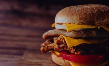 Ev yapımı hamburger veya kahverengi kağıt üzerinde sandviç. Lezzetli sandviç hamburger eti veya domuz jambon peynir ve taze sebze ile. Hamburger veya sandviç popüler fast food brunch veya öğle yemeği için olur. Peynir