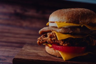 Ev yapımı hamburger veya kahverengi kağıt üzerinde sandviç. Lezzetli sandviç hamburger eti veya domuz jambon peynir ve taze sebze ile. Hamburger veya sandviç popüler fast food brunch veya öğle yemeği için olur. Peynir