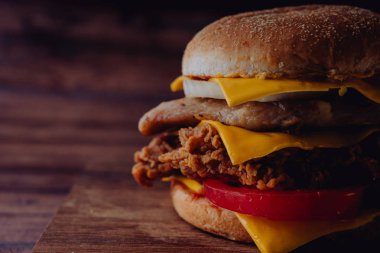 Ev yapımı hamburger veya kahverengi kağıt üzerinde sandviç. Lezzetli sandviç hamburger eti veya domuz jambon peynir ve taze sebze ile. Hamburger veya sandviç popüler fast food brunch veya öğle yemeği için olur. Peynir