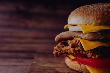 Ev yapımı hamburger veya kahverengi kağıt üzerinde sandviç. Lezzetli sandviç hamburger eti veya domuz jambon peynir ve taze sebze ile. Hamburger veya sandviç popüler fast food brunch veya öğle yemeği için olur. Peynir