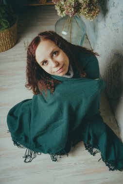 Kız katta oturan bir battaniyeye sarılmış. kavram: üzüntü, üzüntü ve melankoli