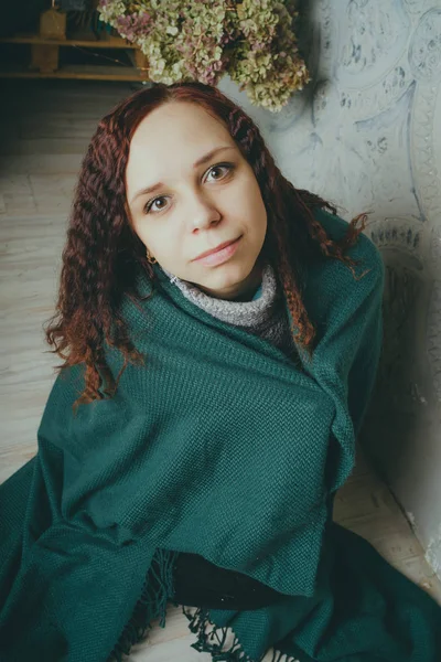 girl wrapped in a blanket, sitting on the floor. concept: sadness, sadness and melancholy