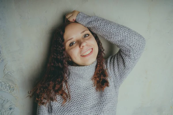 Una Ragazza Con Maglione Che Posa Contro Muro Grigio Donna — Foto Stock