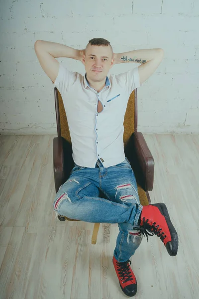 Емоційний Офісний Працівник Татуюванням Хлопець Сидить Стільці Стіні Білої Цегли — стокове фото