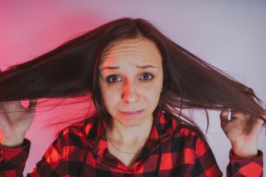 Bir kadının saç, parlak ve duygusal bir kadın ile ilgili sorunlar. Saç bakım hatalar. Kuru, zarar görmüş saçları tutan kız.