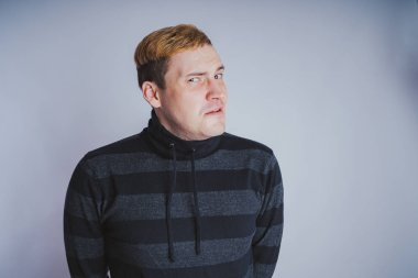 Duygusal bir adam, iş tarzı kıyafetler portresi: kazak ve kot pantolon. duygusal portre. kısa saç ve temiz cilt. Genç acımasız adam kısa saçlı, duygusal portre.