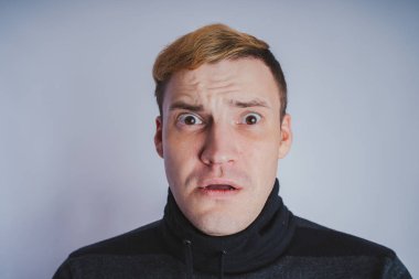 Duygusal bir adam, iş tarzı kıyafetler portresi: kazak ve kot pantolon. duygusal portre. kısa saç ve temiz cilt. Genç acımasız adam kısa saçlı, duygusal portre.