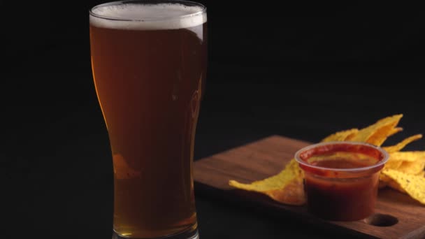 Glas Bier Und Chips Auf Schwarzem Hintergrund — Stockvideo