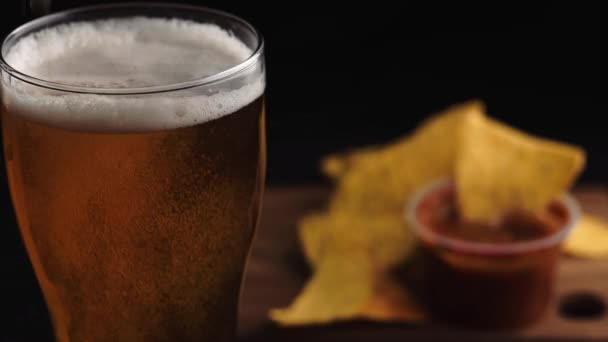 Glas Bier Und Chips Auf Schwarzem Hintergrund — Stockvideo