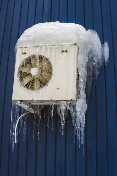 Air conditioning in ice, severe winter. White air conditioner