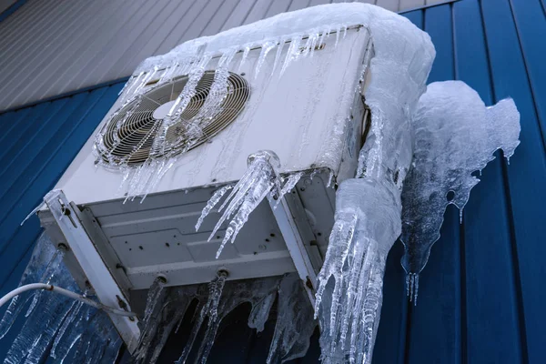 Air conditioning in ice, severe winter. White air conditioner