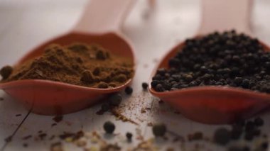 Beyaz ahşap arka planda turuncu kaşıkla baharatlar. Lezzetli yemekler. Paprika, karabiber, doğal deniz tuzu kurutulmuş kırmızı acı biberle karıştırılmış rengarenk baharat yakın plan.