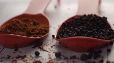 Beyaz ahşap arka planda turuncu kaşıkla baharatlar. Lezzetli yemekler. Paprika, karabiber, doğal deniz tuzu kurutulmuş kırmızı acı biberle karıştırılmış rengarenk baharat yakın plan.