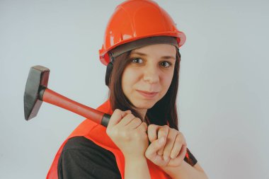 Kız Oluşturucu ile çekiç el, bir kavram: kız onarım yapıyor. Bir kadın bir kask ve bir yol işçi veya arazi suretinde bir turuncu yelek