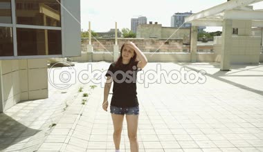 Kız kavurucu güneşte yürüyor ve doğru yolu arıyor. Şehirde turistler dolaşıyor.