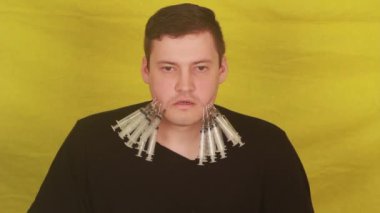  Yanağında şırıngalar olan bir adam.
