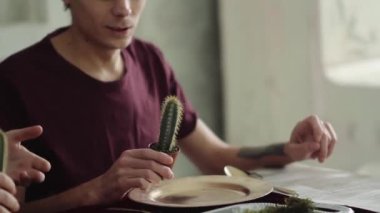 İki adam kaktüsleri yiyor. Bir adam kaktüs yer.