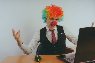 Office worker in clown wig, clown concept at work. Businessman at the computer, work on a laptop clipart