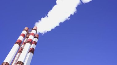 Endüstri, mavi gökyüzü arka planında duman olan borular