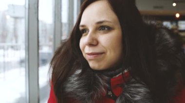 Kadın kış günü pencerenin yanında.  