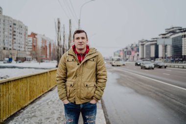 Şehir yolunda günlük giysiler içinde genç yakışıklı bir adam.