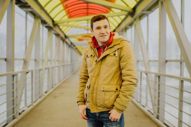 Şehir yolunda günlük giysiler içinde genç yakışıklı bir adam.