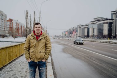Şehir yolunda günlük giysiler içinde genç yakışıklı bir adam.