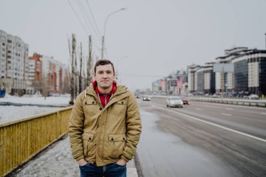 Şehir yolunda günlük giysiler içinde genç yakışıklı bir adam.