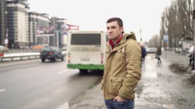 Şehir yolunda günlük giysiler içinde genç yakışıklı bir adam.