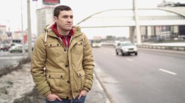Şehir yolunda günlük giysiler içinde genç yakışıklı bir adam.