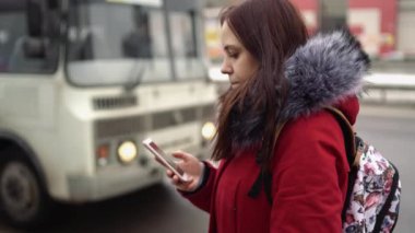 Kışın şehirde akıllı telefon kullanan bir kadın