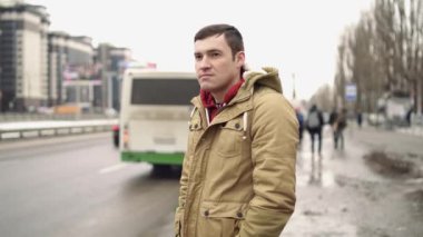  Şehirde günlük giysiler içinde genç bir adam.