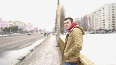  Şehirde günlük giysiler içinde genç bir adam.