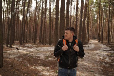 Ormanda sırt çantalı gezgin bir adam. Sırt çantalı yakışıklı adamın portresi.