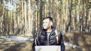 Backpack yürüyüş Travel Lifestyle kavramı ile Traveler Man. Gezgin ormandan geçiyor. Adam ormanda kayboldu ve haritada yolu arıyor.