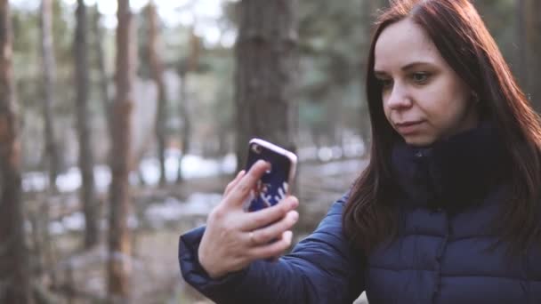 春天森林里拿着智能手机自私自利的年轻女子 — 图库视频影像
