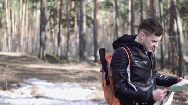 旅行人与背包徒步旅行旅行生活方式的概念 旅行者穿过森林 那家伙在树林里迷路了 在地图上寻找路 — 图库视频影像