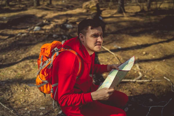 배낭에 사람이 숲에서 트렁크에 앉아서 빨간색 스포츠 Woodsyoung에 — 스톡 사진