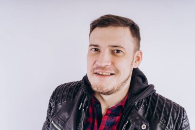 Deri ceketli genç erkek portresi üzerinde moda ceketli adam kadar zipping ve beyaz arka plan üzerinde kamera gülümseyerek