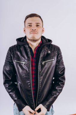 Deri ceketli genç erkek portresi üzerinde moda ceketli adam kadar zipping ve beyaz arka plan üzerinde kamera gülümseyerek