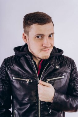 Deri ceketli genç erkek portresi üzerinde moda ceketli adam kadar zipping ve beyaz arka plan üzerinde kamera gülümseyerek