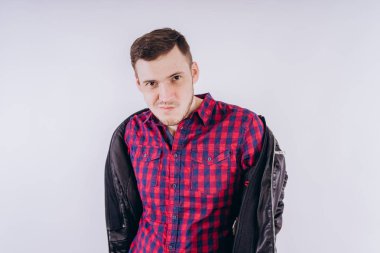 Kırmızı ekose gömlek beyaz arka plan karşı omuz deri ceket tutan genç yakışıklı erkek omuz portresi ceket ile Cool adam