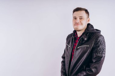 Deri ceketli genç erkek portresi üzerinde moda ceketli adam kadar zipping ve beyaz arka plan üzerinde kamera gülümseyerek